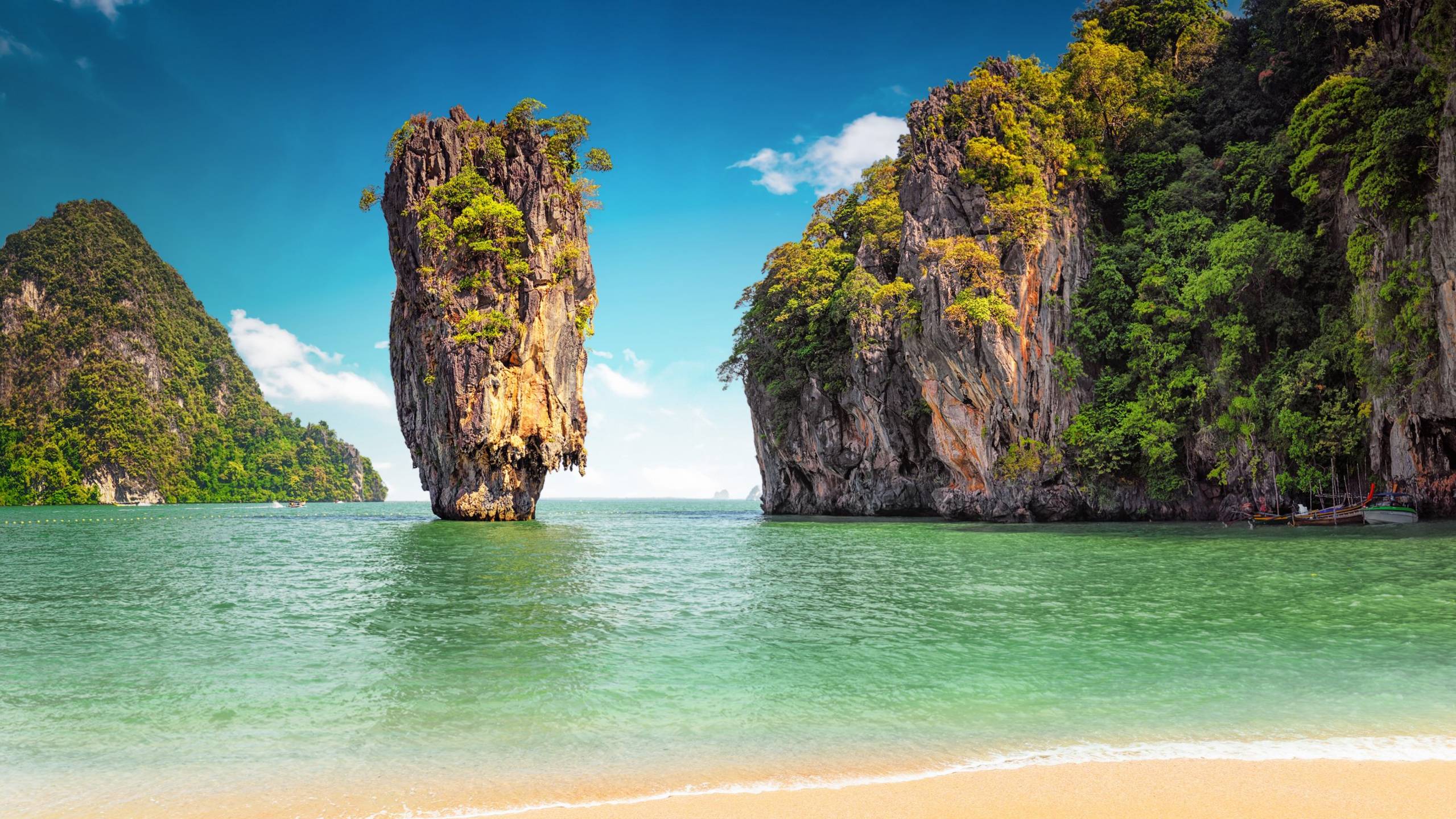 Towering limestone karsts rise majestically from the emerald waters of Thailand's Phang Nga Bay.