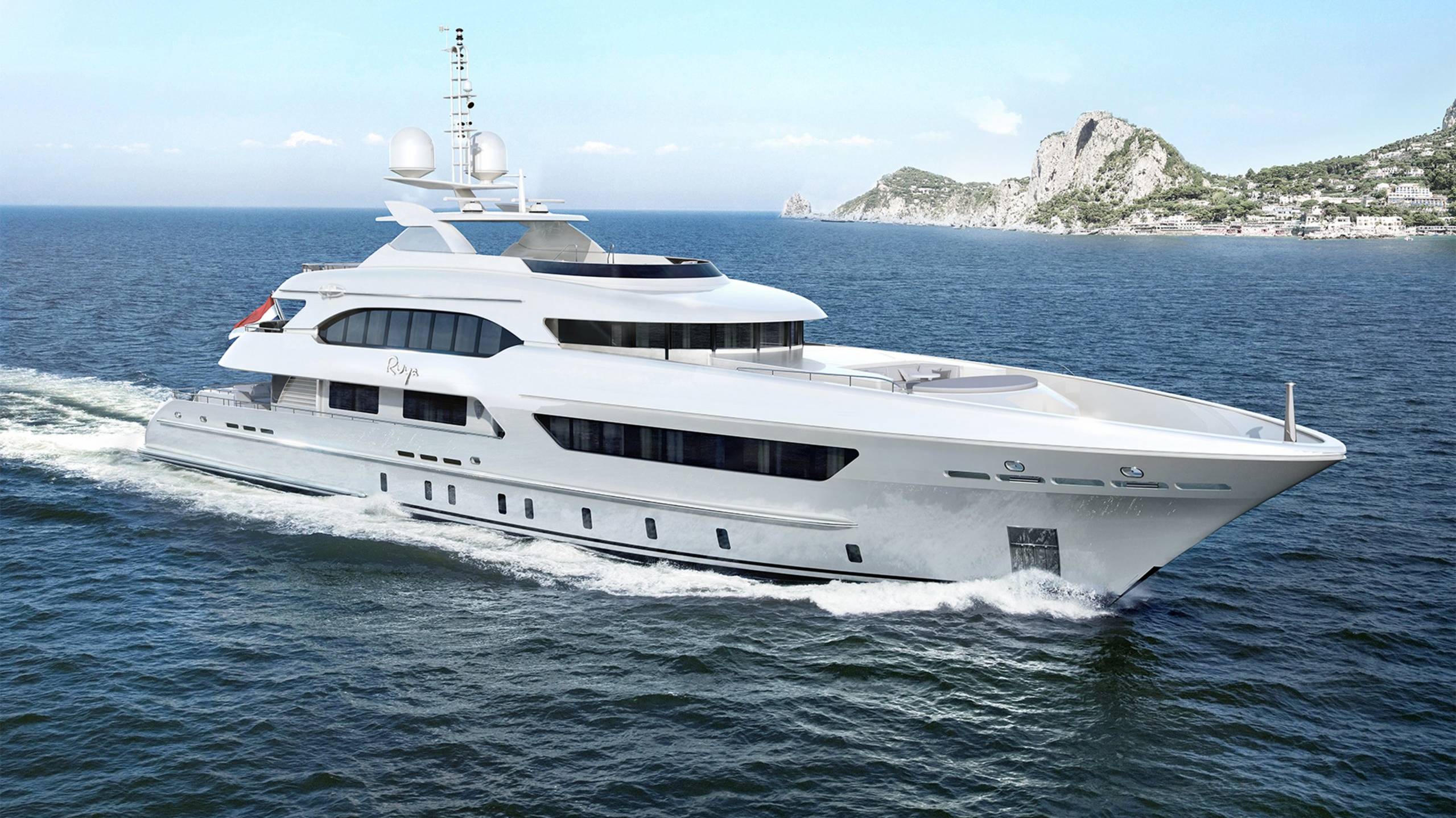 A luxurious white yacht glides through the deep blue sea with a picturesque coastline in the background.