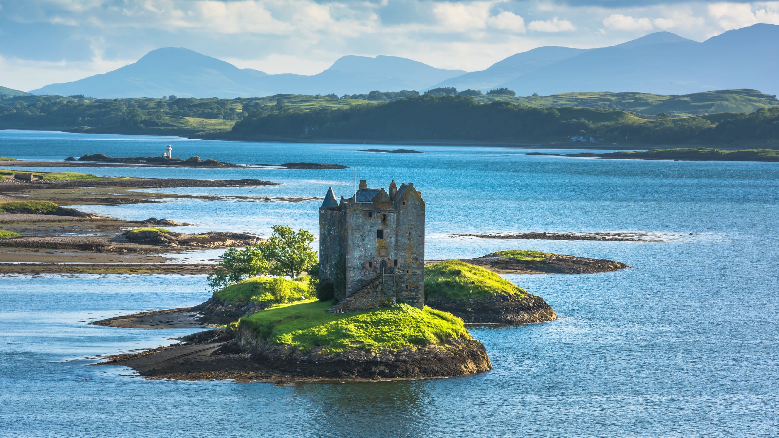 Eilean Donan Castle stands majestically on its island, surrounded by the serene blue waters of Loch Duich.