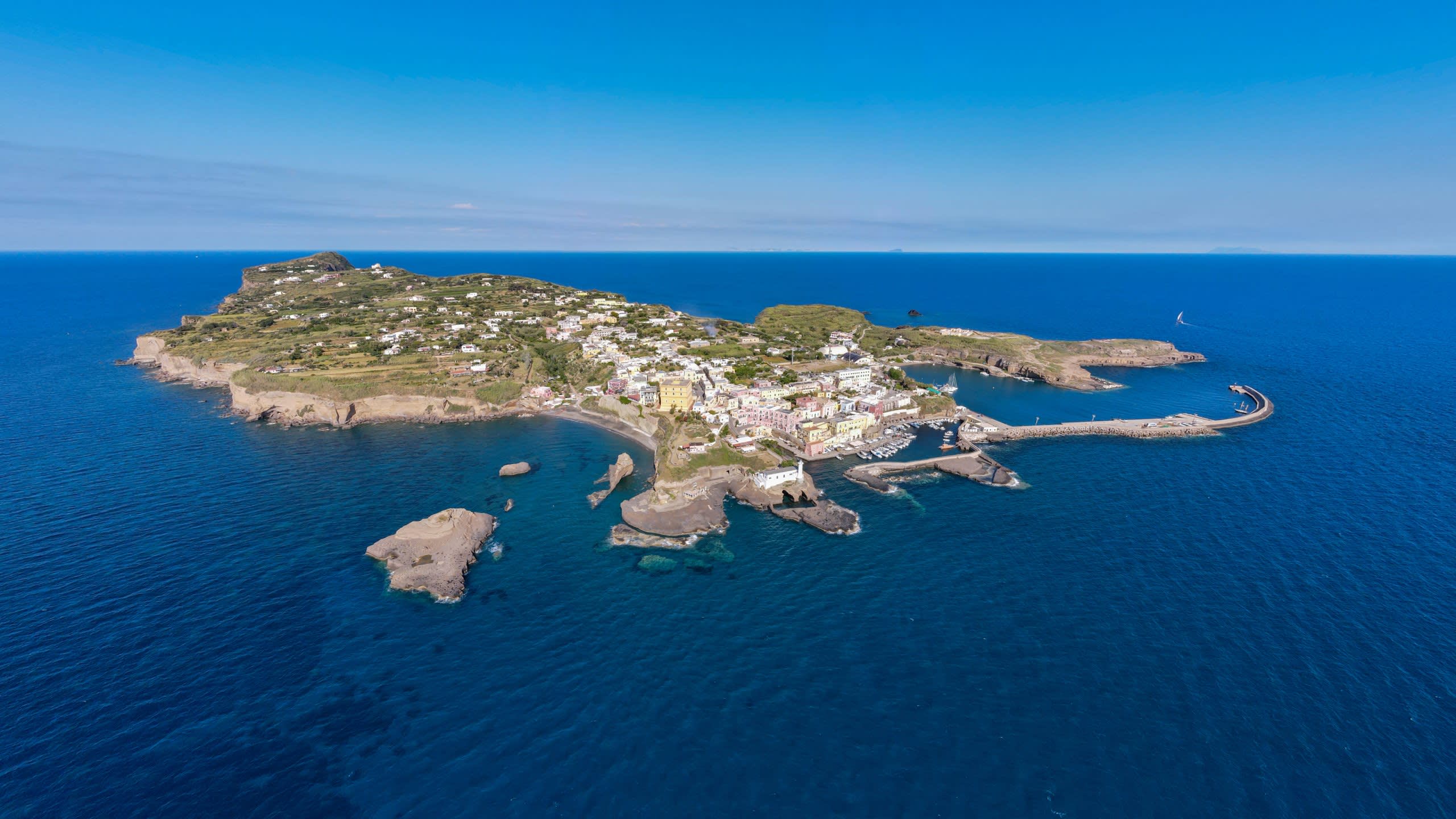 A vibrant coastal town nestles on a verdant island surrounded by the deep blue sea.