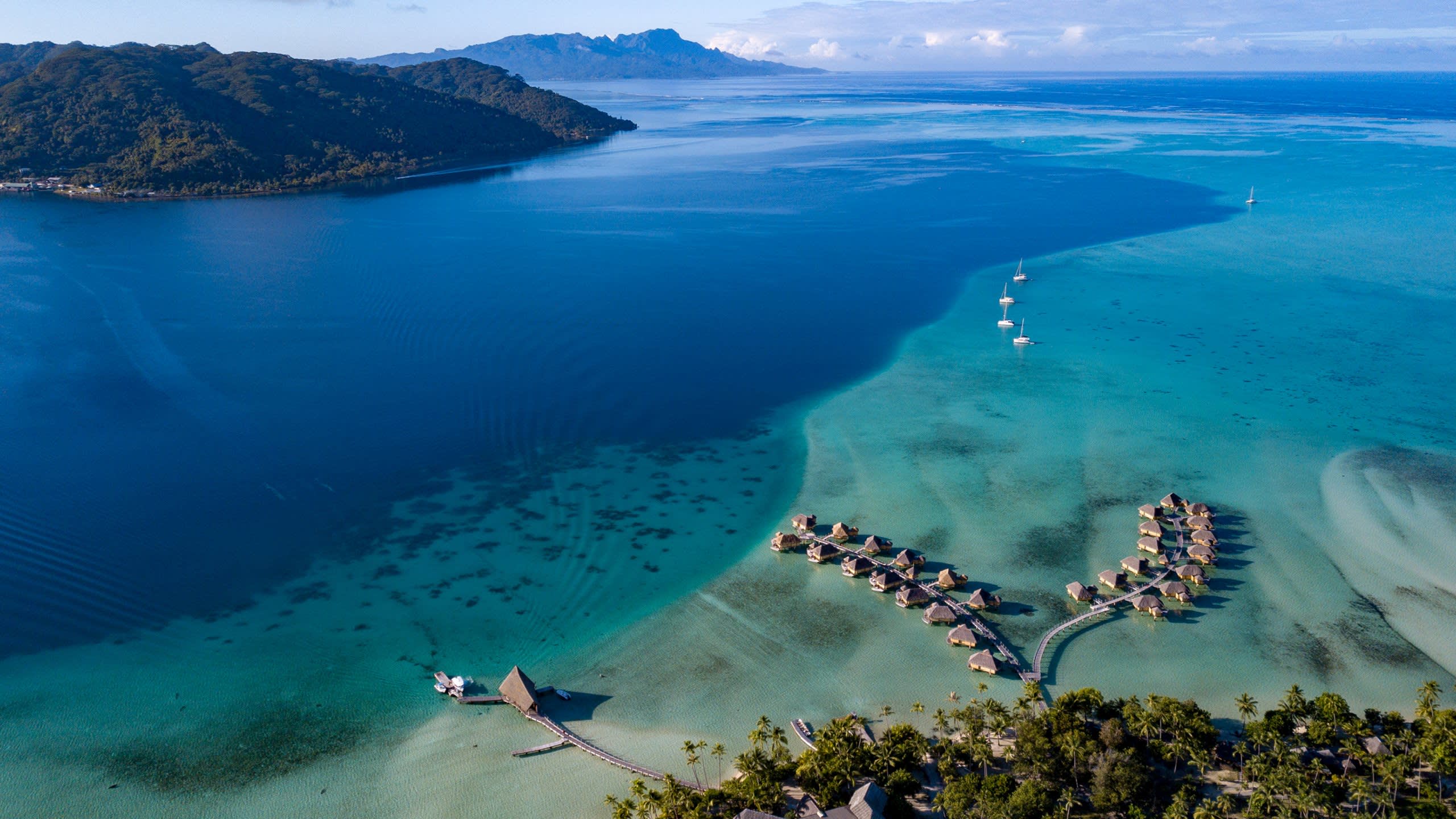 Long shot of blue seas with holiday homes built over the water