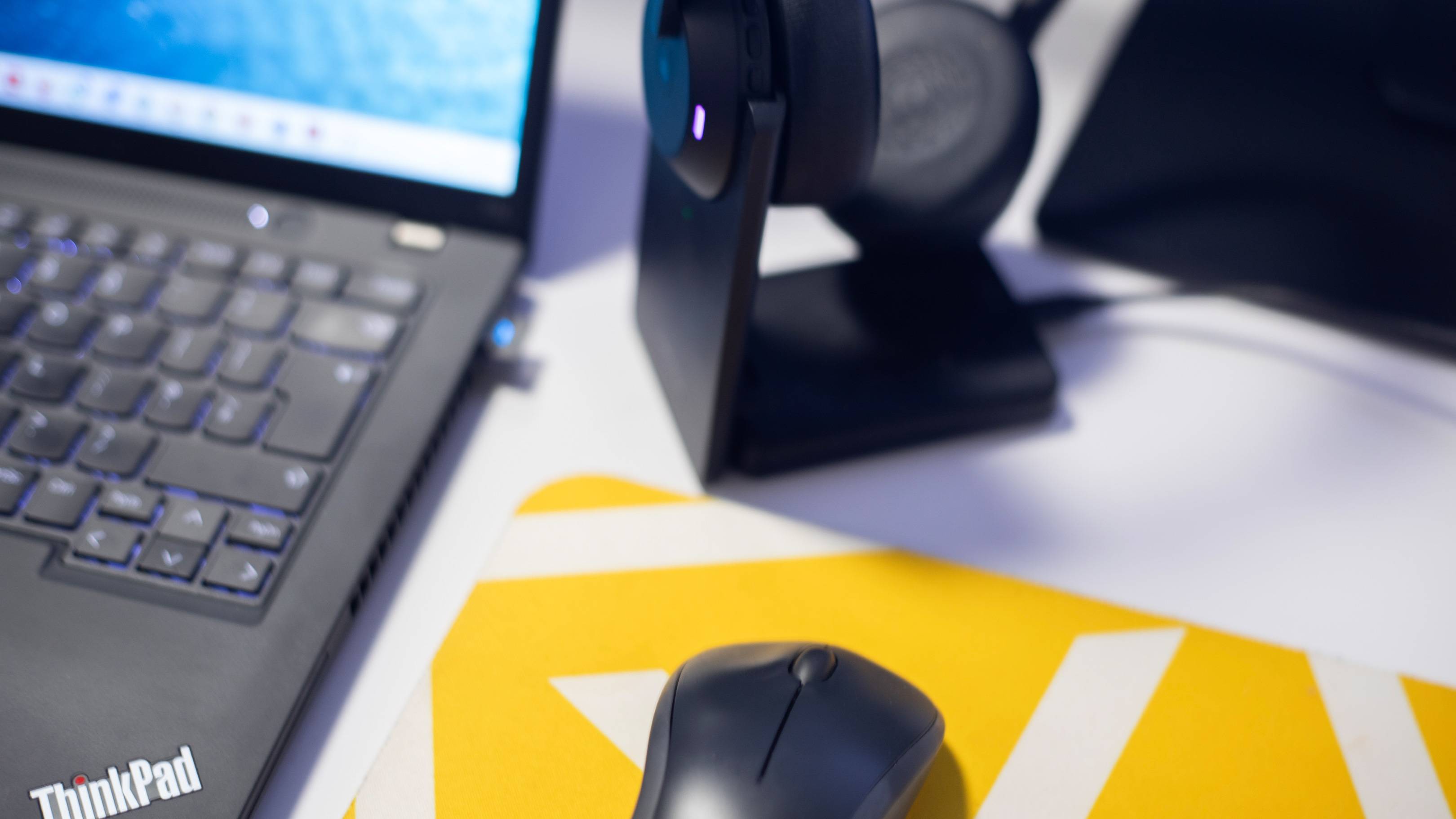 A laptop with a ThinkPad logo, a computer mouse, and a yellow background are visible in the image.