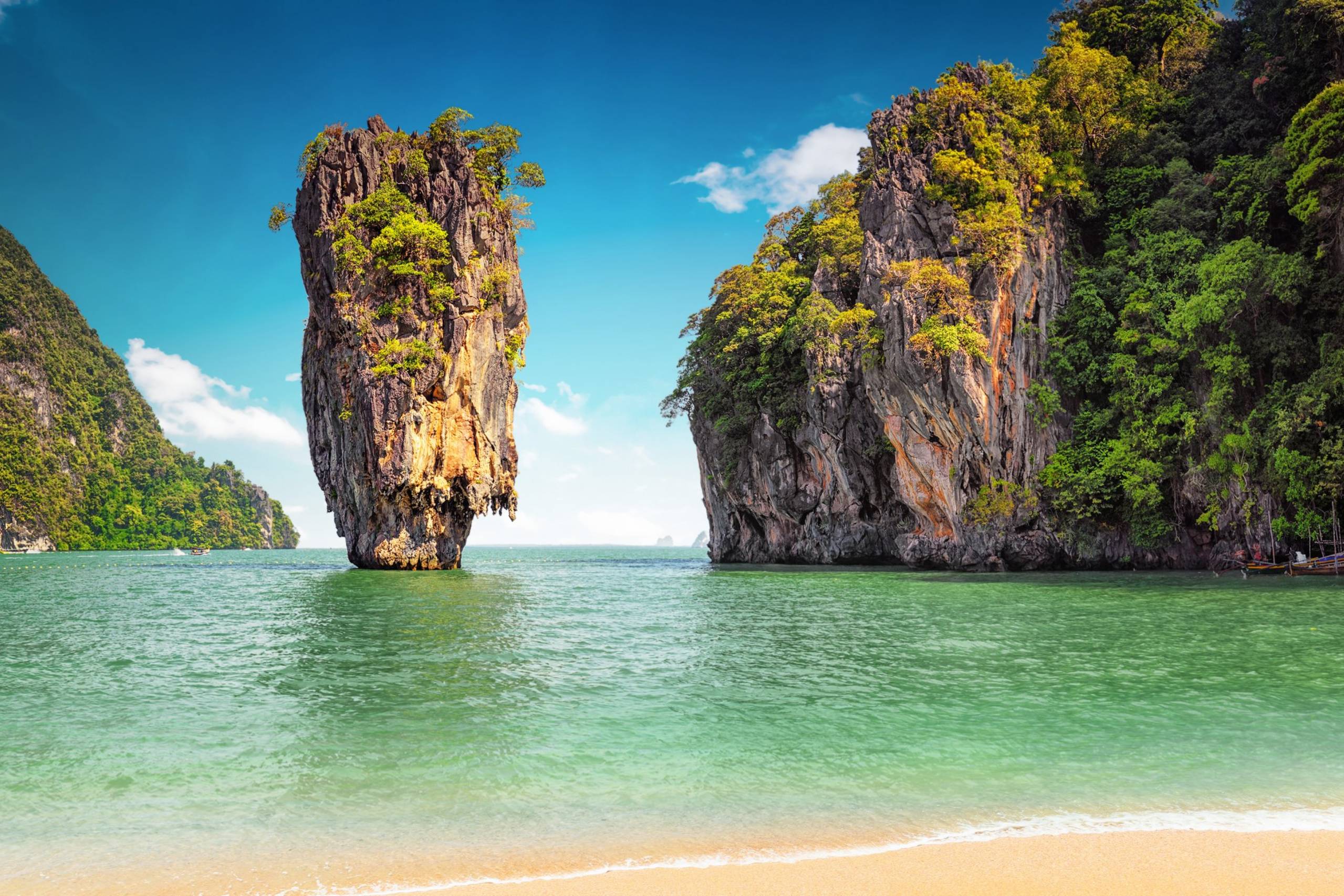 Towering limestone karsts rise majestically from the emerald waters of Thailand's Phang Nga Bay.