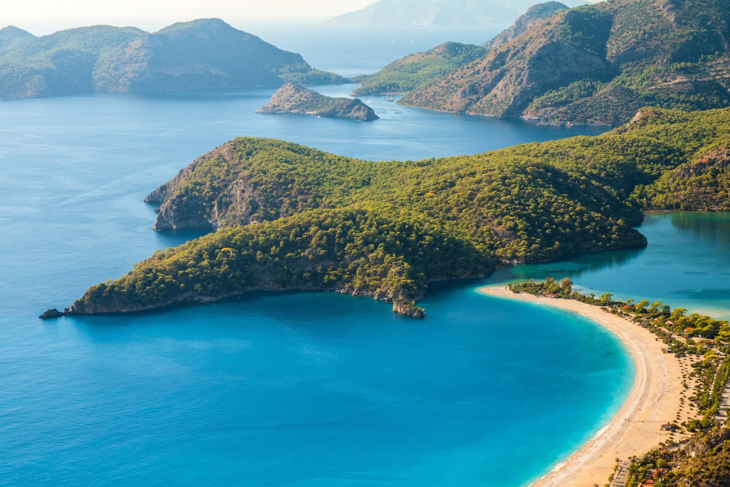 Lush green mountains embrace the turquoise waters of a stunning coastal paradise.