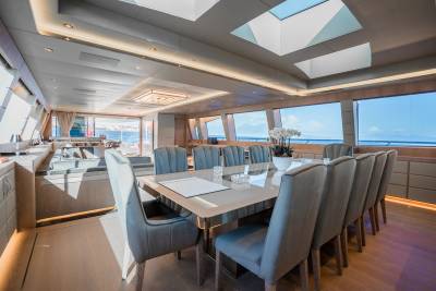 A spacious yacht dining room offers a luxurious setting for guests to enjoy meals with a stunning ocean view.
