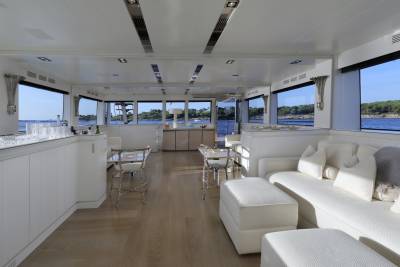 Luxurious white seating and a well-stocked bar create an inviting space aboard this elegant yacht.