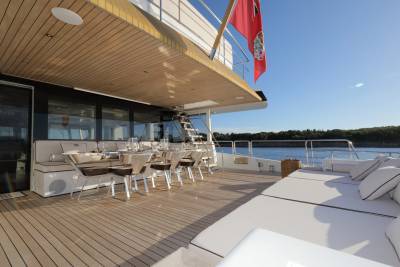 Luxurious outdoor dining and lounging areas await on this elegant yacht, perfect for enjoying the sun and sea.