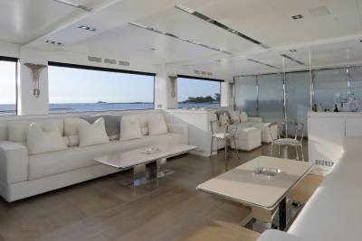 Luxurious yacht interiors offer a serene escape with panoramic ocean views and plush white furnishings.