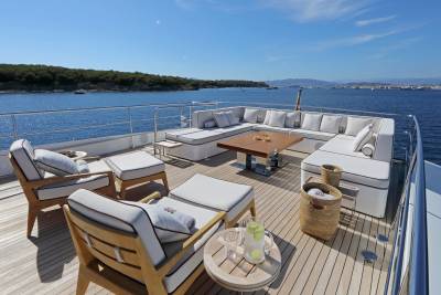 Relax on the spacious deck of this luxury yacht, surrounded by the sparkling blue sea and lush green islands.