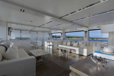 Luxurious yacht interiors offer stunning views of the Mediterranean coastline from expansive windows.