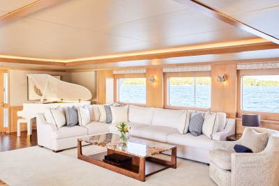 A luxurious yacht salon offers breathtaking ocean views from its plush seating and grand piano.