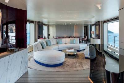 Luxurious yacht interiors feature a curved sectional sofa and sleek modern furniture with ocean views.