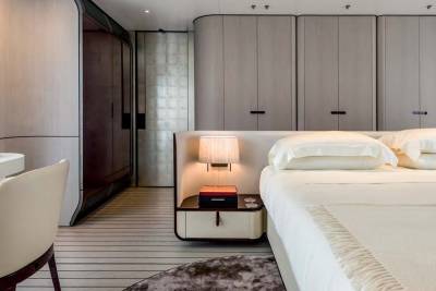 Luxurious bedroom features a plush bed, elegant cabinetry, and a sleek desk area.
