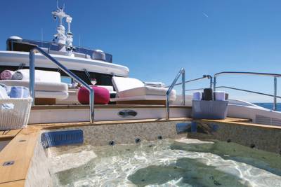 A luxurious yacht features a steaming hot tub on its deck, perfect for relaxing with a view of the ocean.