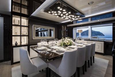 A sophisticated dining room aboard a luxury yacht offers an elegant setting for a memorable meal with a stunning ocean view.