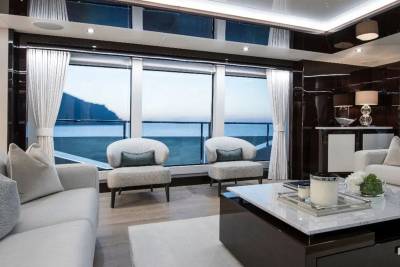 Luxurious yacht interiors offer stunning ocean views through expansive windows and elegant seating arrangements.