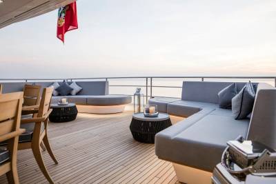 Relax on the luxurious deck of a yacht, surrounded by comfortable seating and the serene beauty of the ocean at sunset.