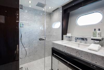 Luxurious marble and dark wood finishes create a serene and elegant bathroom sanctuary on this yacht.
