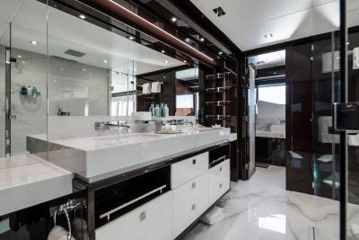 Luxurious yacht bathroom features a sleek double vanity, marble accents, and a glass-enclosed shower.