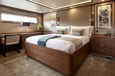 Luxurious wood finishes and elegant artwork create a serene and sophisticated master suite on this opulent yacht.