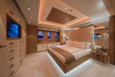 Luxurious yacht bedroom features a floating bed, integrated entertainment system, and panoramic oval windows overlooking the sea.