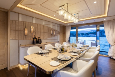 An elegant dining room on a yacht offers a sophisticated setting for a meal with a stunning view of the sea.