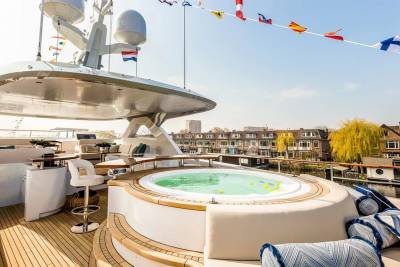 Relax in the luxurious onboard jacuzzi while enjoying picturesque canal views from this stunning yacht deck.