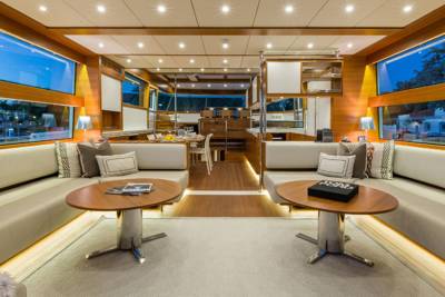 Luxurious yacht interiors feature plush seating and expansive windows offering stunning views of the twilight harbor.