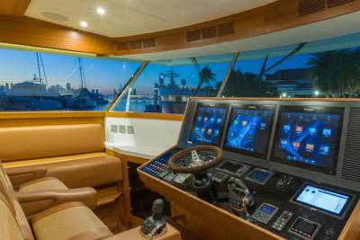 The modern helm of a luxury yacht offers panoramic views of a city skyline at dusk.
