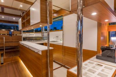 Sleek wooden cabinetry and modern appliances create a luxurious galley on this elegant yacht.