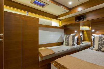 Two twin beds with patterned pillows and warm blankets are neatly made in this cozy cabin.