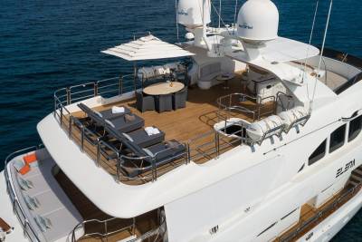 Luxurious sun loungers and a dining set await guests on the expansive deck of the yacht Elena.