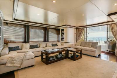Relax in luxurious comfort within this yacht's elegant salon, offering stunning ocean views through expansive sliding doors.