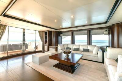Luxurious yacht salon offers stunning ocean views through expansive windows and comfortable seating for relaxation.