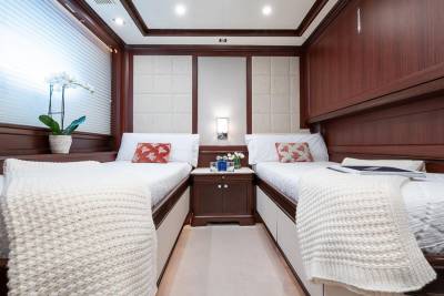 Luxurious twin beds with plush throws and decorative pillows await in this elegant stateroom.