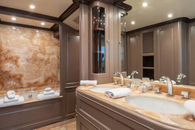 Luxurious marble countertops and a deep soaking tub create an opulent retreat in this yacht's master bathroom.