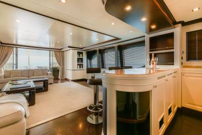 Relax in the luxurious lounge area of this yacht, complete with a stylish bar and comfortable seating overlooking the ocean.