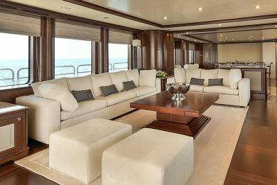 Luxurious cream sofas and a dark wood coffee table create a sophisticated lounge area overlooking the ocean.