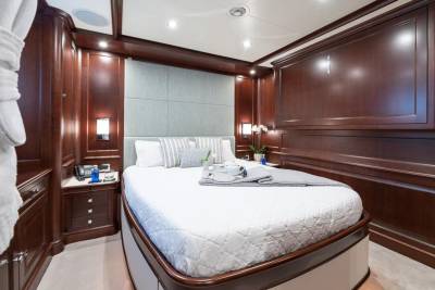Luxurious dark wood paneling and a plush bed create a serene retreat in this elegant stateroom.