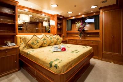 Luxurious mahogany cabinetry and a floral-patterned bed create an opulent retreat aboard this elegant yacht.