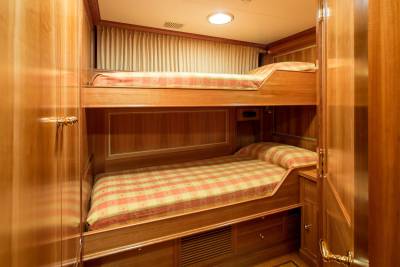 Luxurious wooden bunk beds with checkered bedding offer a cozy retreat on this elegant yacht.