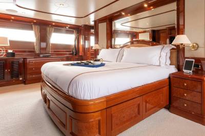 Luxurious cherry wood accents and plush white bedding create an opulent retreat aboard this elegant yacht.