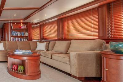 Luxurious yacht interiors feature plush seating, rich wood accents, and large windows with adjustable blinds for a serene atmosphere.