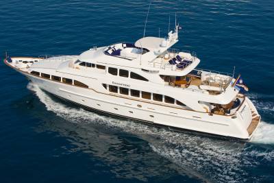 The luxurious yacht Enchantress glides through the deep blue ocean, leaving a foamy wake behind.