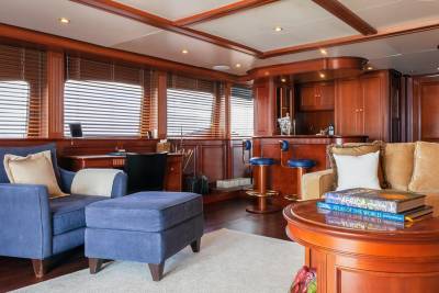 Luxurious wood paneling and plush seating create an inviting atmosphere in this yacht's elegant lounge and bar area.