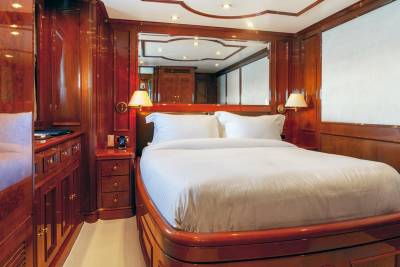 Luxurious mahogany paneling and a plush bed create an opulent retreat aboard this elegant yacht.