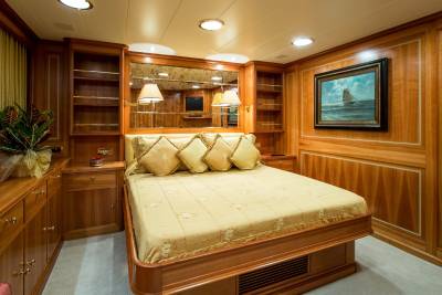 Luxurious wood paneling and a plush bed create a serene and elegant master suite on this yacht.