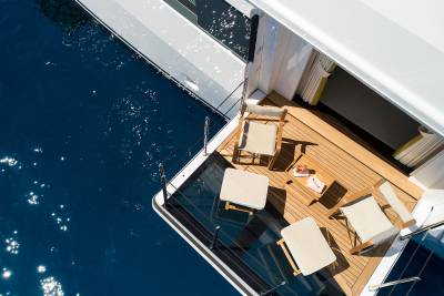 Relax on the teak deck of this luxurious yacht, enjoying drinks and the sparkling blue ocean.