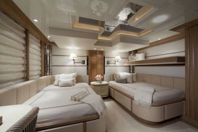 Luxurious twin beds with plush bedding offer a serene retreat within this elegantly appointed yacht cabin.