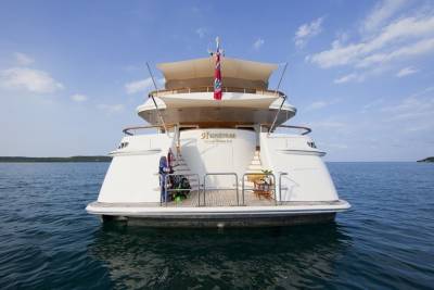 The luxurious yacht Huntress, docked in George Town, C.I., awaits its next adventure on the tranquil blue waters.